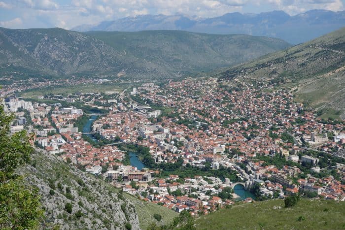 Mostar: Discovering the scars of the war that rocked Bosnia. The bombed out buildings that remain, Bosnia and Herzegovina, Bombed out buildings, sniper towner, exploring the sniper tower, how to get in, is it safe, mountains, cross, view from sniper tower, bullet holes, yugoslavia, balkan war, siege, fighting, croats, serbs, bosnians, muslims, front line, history