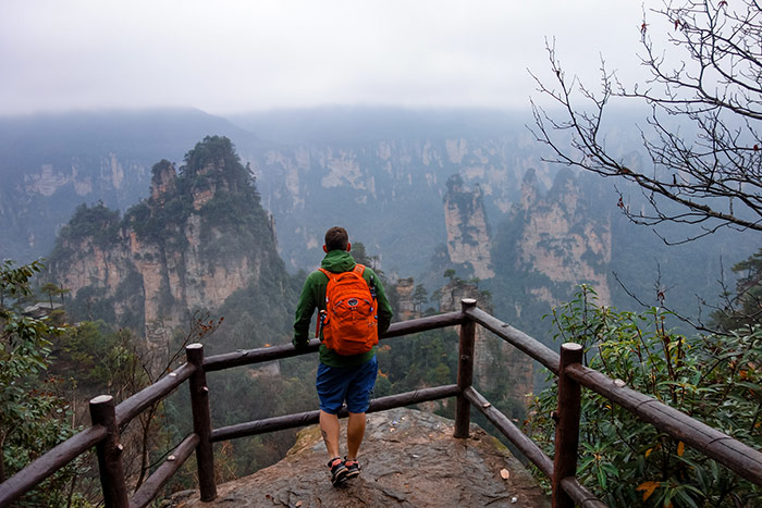 Shorty standing looking out next to a fence at one of the viewpoints when visiting zhangjiajie, china