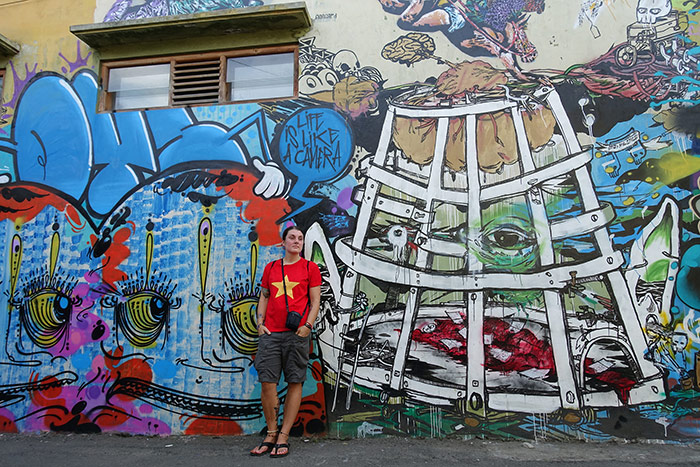 Nic leaning against a wall with street art on it in Yogyakarta, Indonesia